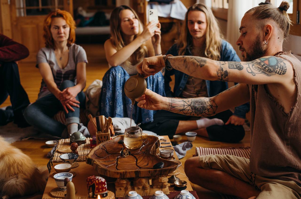 A tea ceremony room — a circle of tongue drums and cushions in warm light